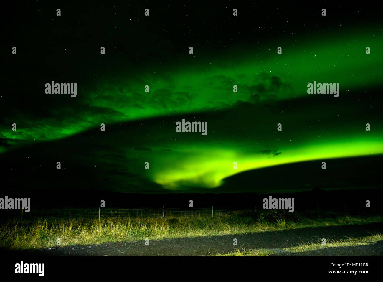 Increíble "Luces del Norte" sobre el cielo de Islandia. Las brillantes luces de baile de la Aurora Boreal. Luz verde en el hermoso paisaje nocturno. Foto de stock