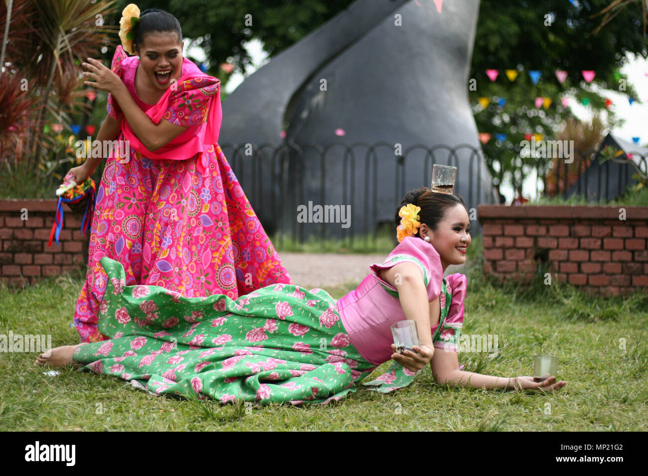 Manila, Filipinas. El 20 de mayo de 2018. Las mujeres realizan filipinos  nativos bailan vestidos con trajes hechos de materiales autóctonos. El  Departamento de Turismo celebró Flores de mayo festival en el