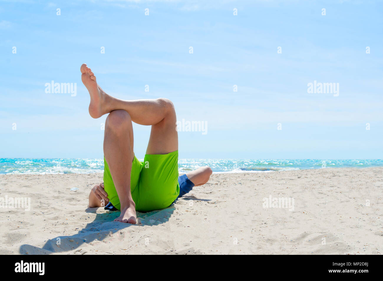 El hombre tendido sobre su espalda en la playa Fotografía de stock - Alamy