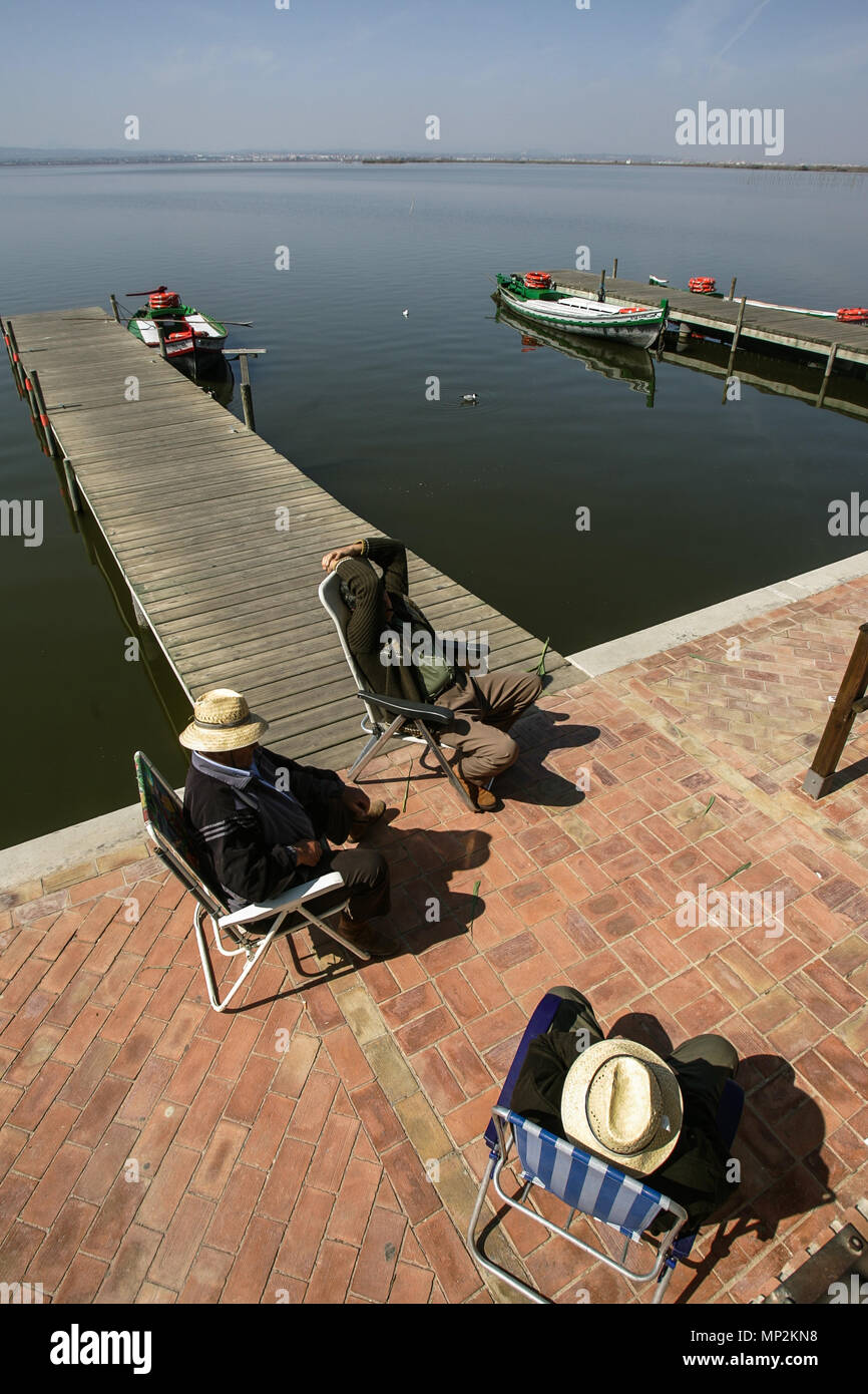 Tres pescadores descanso en el embarcadero de la reserva natural de La Albufera de Valencia Foto de stock
