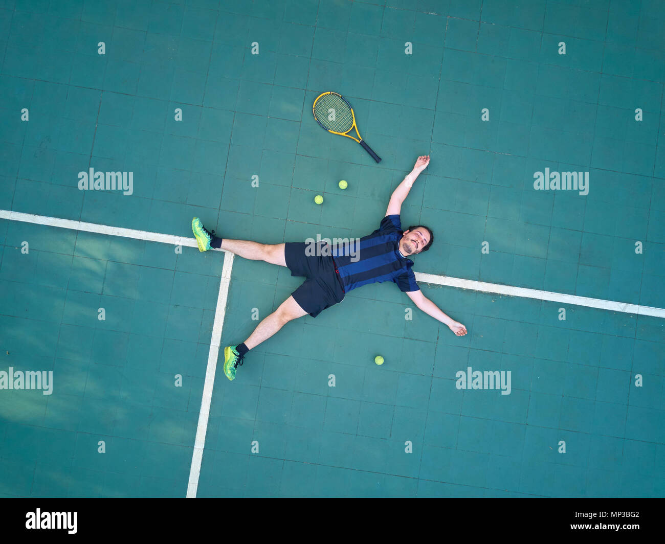 Hombre ganar juego de tenis en la cancha y laicos vista superior Foto de stock