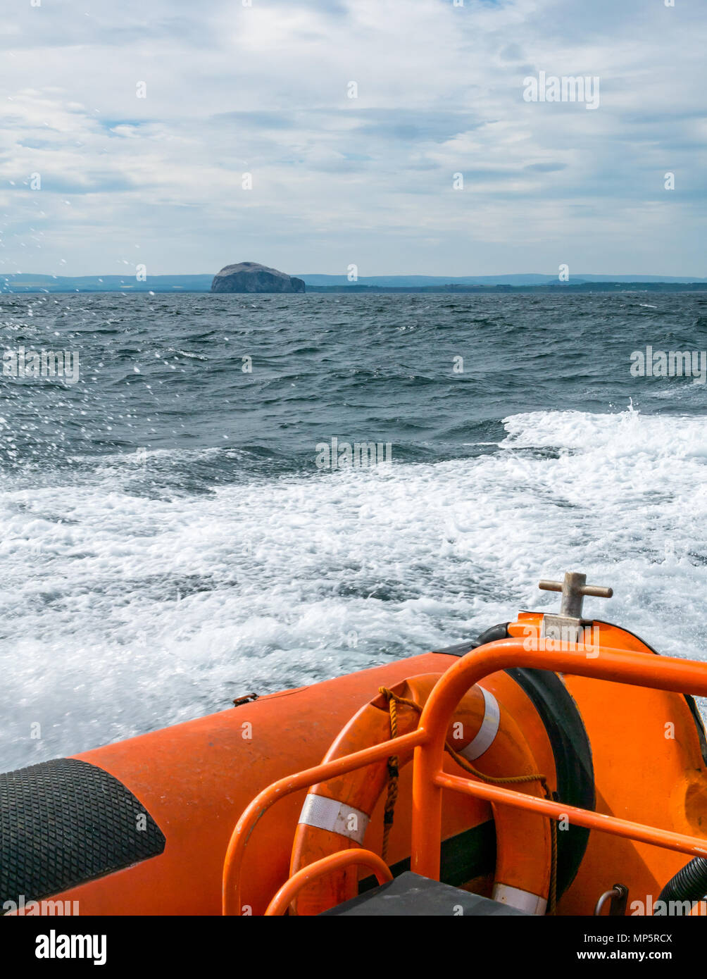 Seafari lancha crear ola despertar en Firth of Forth con Bass Rock colonia de alcatraces en el horizonte, Scotland, Reino Unido Foto de stock