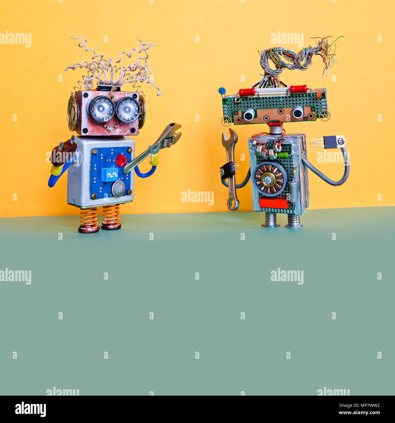 Concepto de servicio de mantenimiento de automatización de robots. Manitas  personajes robóticos con llave de mano y pinzas. Pared amarilla, verde piso  espacio copia de fondo Fotografía de stock - Alamy