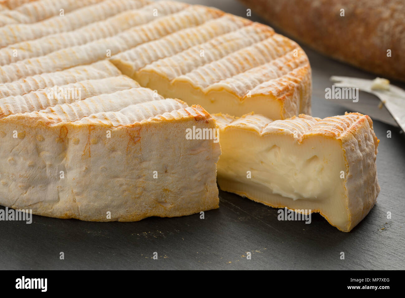 Francés Le Marcaire queso y una cuña en una tabla de quesos de pizarra cerrar Foto de stock