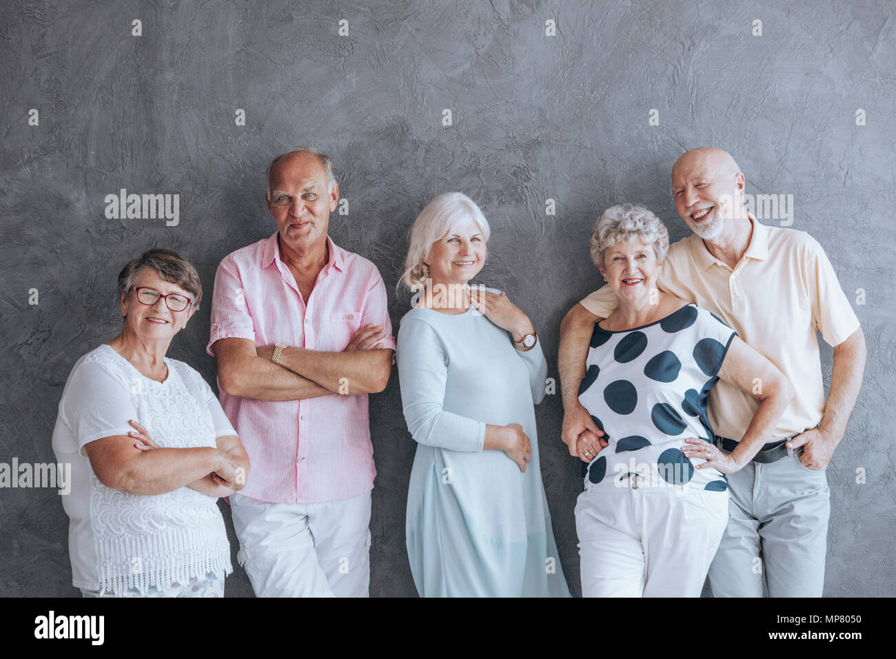 Feliz ancianos en ropa casual contra la pared de hormigón. Los ancianos  amistad concepto Fotografía de stock - Alamy