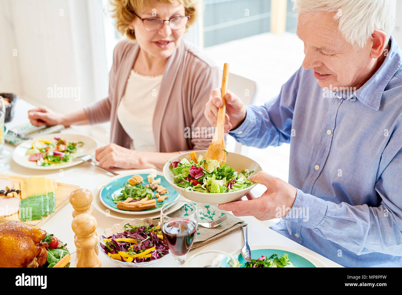 Los abuelos disfrutando de una comida en la cena familiar. Foto de stock