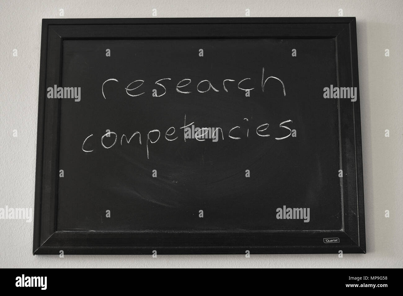 Competencias de investigación escritas en blanco tiza en una pizarra en la pared. Foto de stock