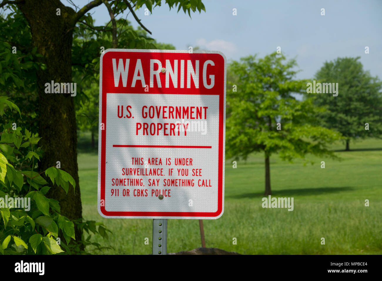 Señal de advertencia por los Estados Unidos de América El gobierno federal esa zona está bajo la vigilancia de la propiedad de la tierra Foto de stock