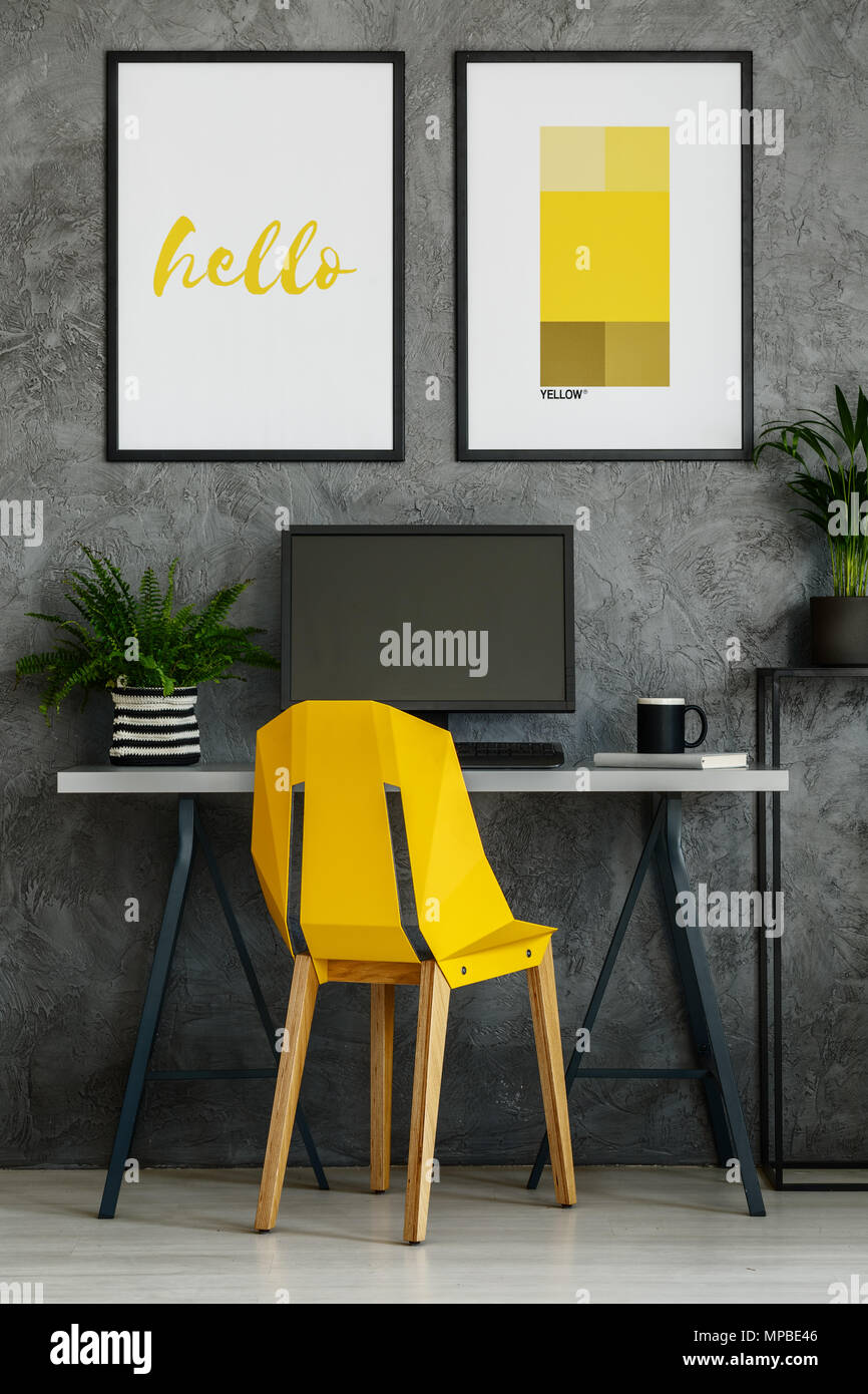 Amarillo canario, escritorio y silla modelo carteles en brillante interior  de oficina Fotografía de stock - Alamy