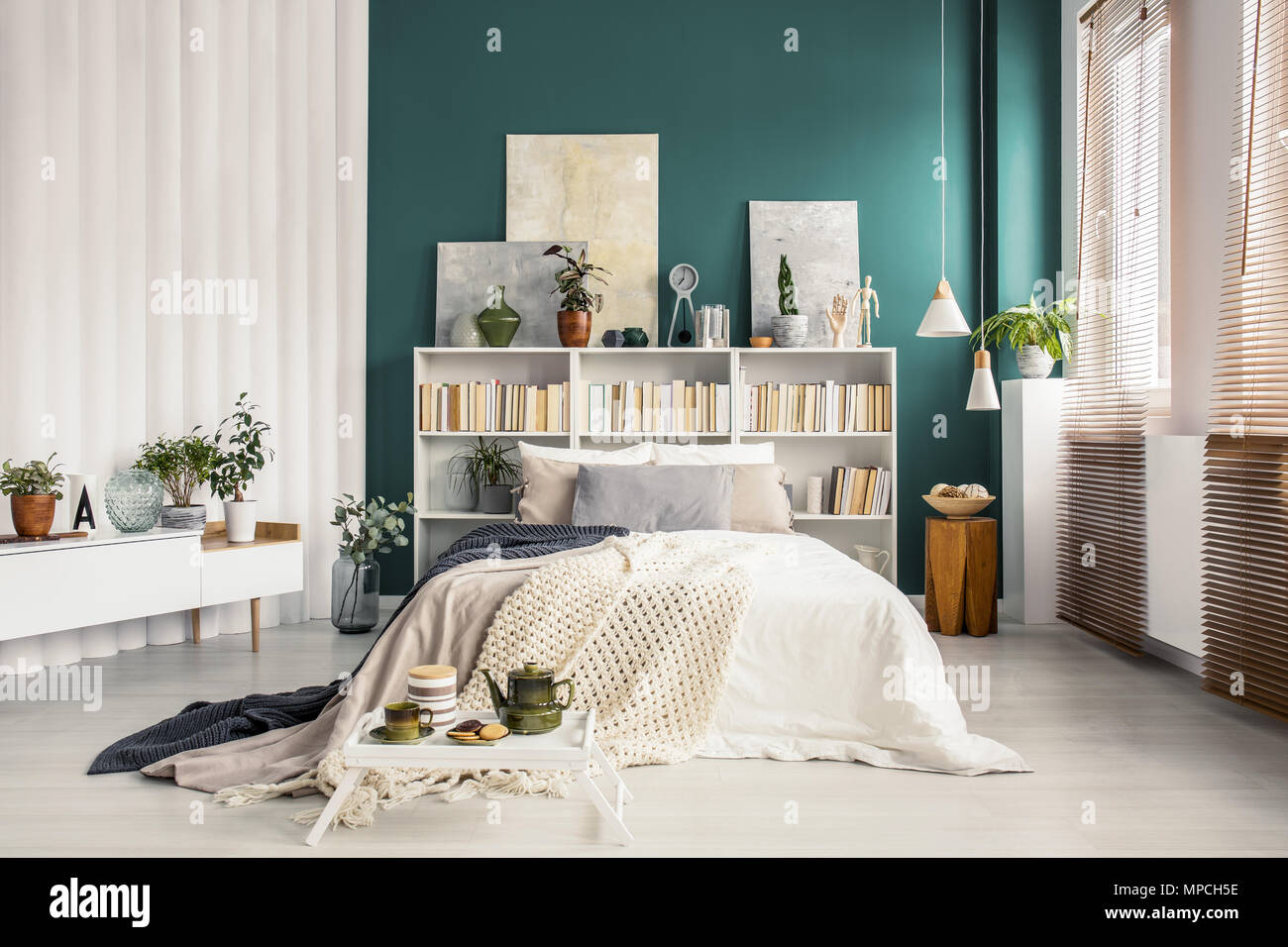 Librero de cabecera con ilustraciones y decoraciones en un elegante color  verde turquesa interior del dormitorio con muebles blancos Fotografía de  stock - Alamy