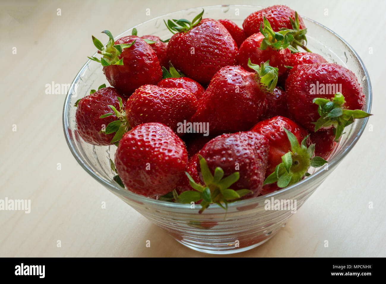 Fresas jugosas frescas en el tazón de vidrio. Fondo rústico. Vista desde arriba. Lugar para el texto. Foto de stock