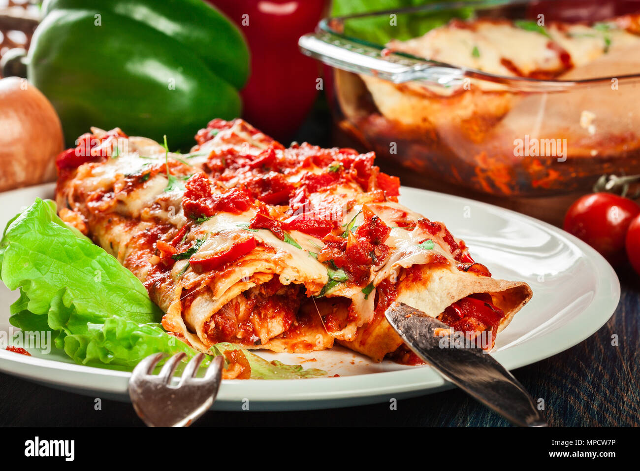 Enchiladas mexicanas tradicionales con carne de pollo, salsa de tomate picante y queso en un