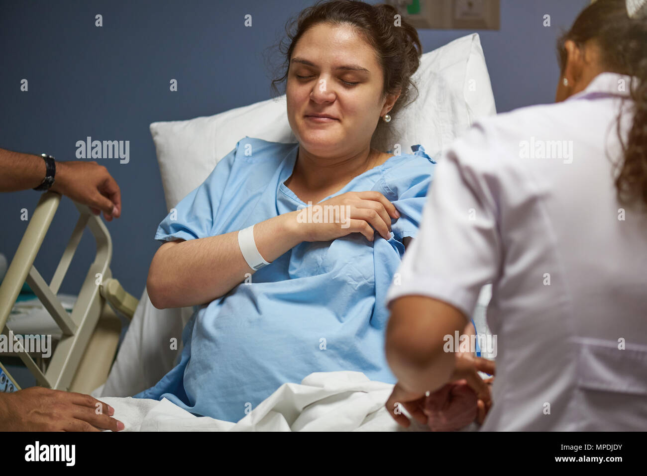 Comprobación de la enfermera en la clínica de salud joven cama Foto de stock