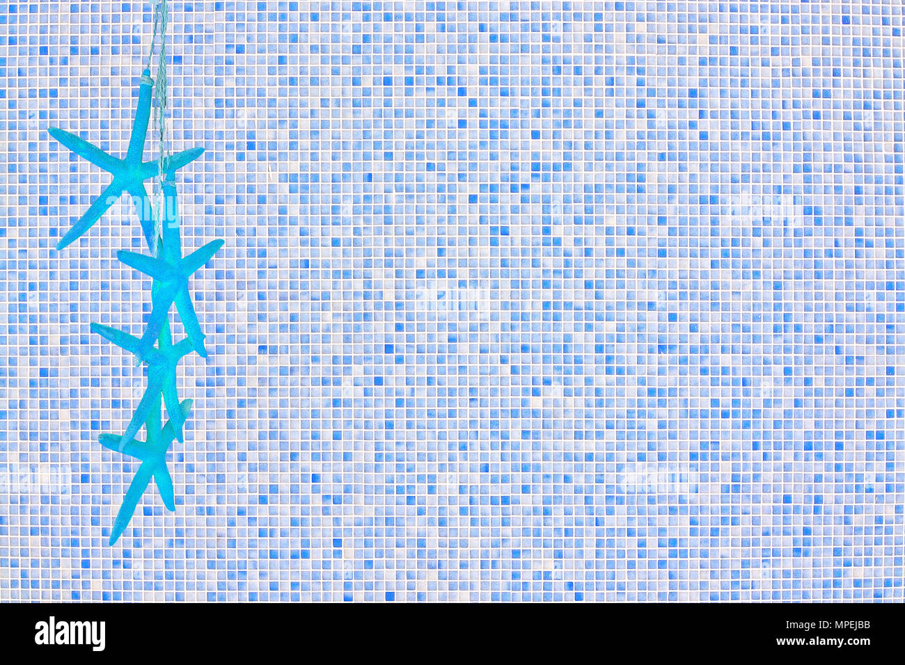 Estrella de mar azul sobre fondo de pared de mosaico en color azul para copiar contexto espacial tema verano Foto de stock