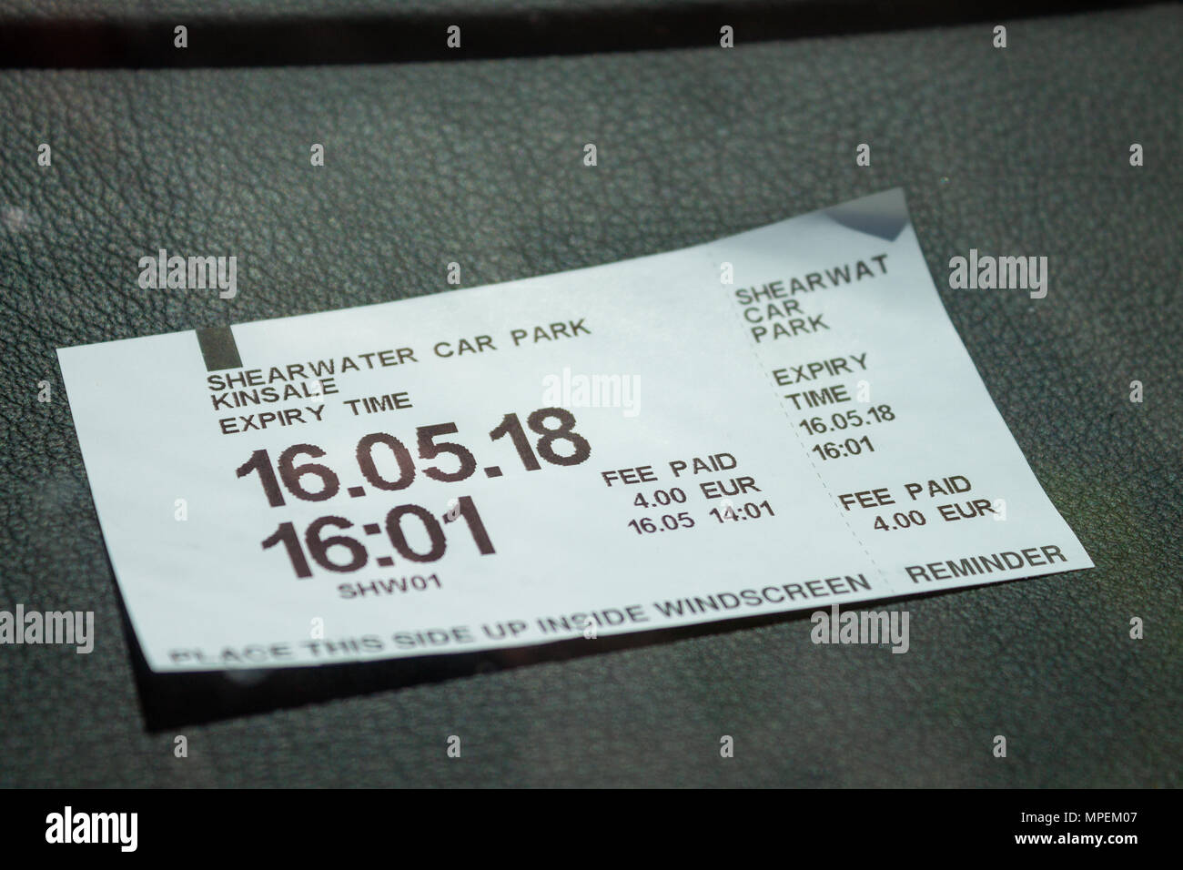 Pagar y mostrar ticket de aparcamiento en la pantalla a través del parabrisas o el parabrisas de un coche, que muestra el coste del parking. Foto de stock