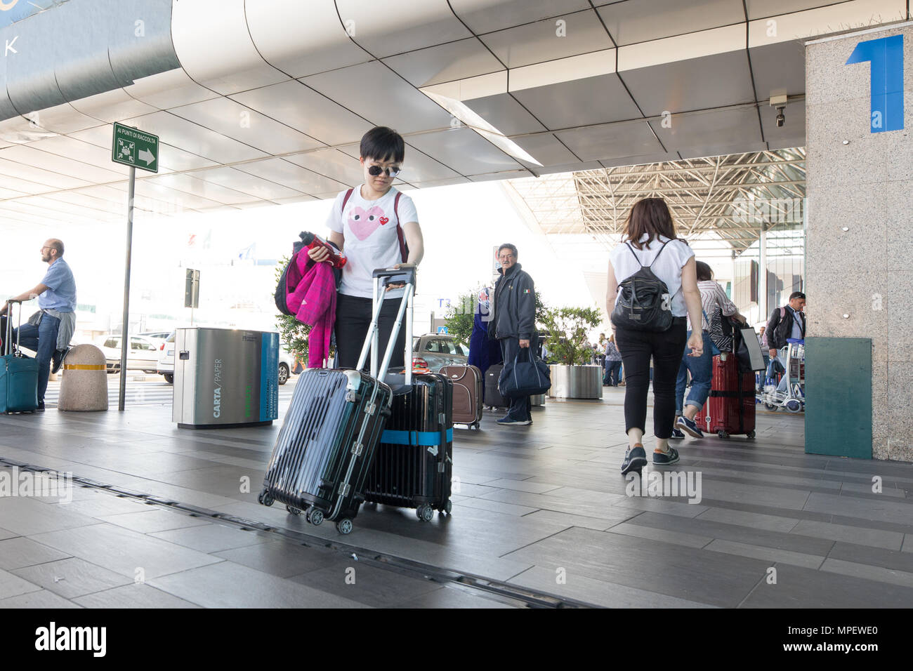 El aeropuerto Fiumicino de Roma, los pasajeros caminando con carro y maleta  Fotografía de stock - Alamy