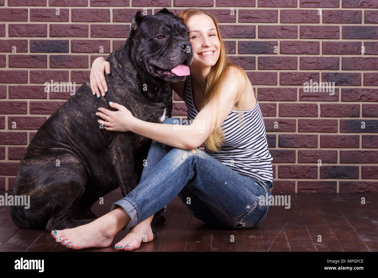 Retrato de una joven abrazando un gran perro Cane Corso Foto de stock
