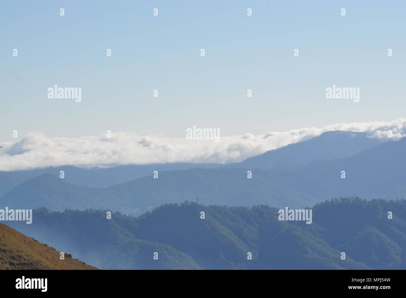 Nubes que cubren las crestas de las montañas de la Cordillera de campo durante las horas tempranas de la mañana visto desde el Monte Ulap durante nuestra caminata por el sendero ecológico. Foto de stock