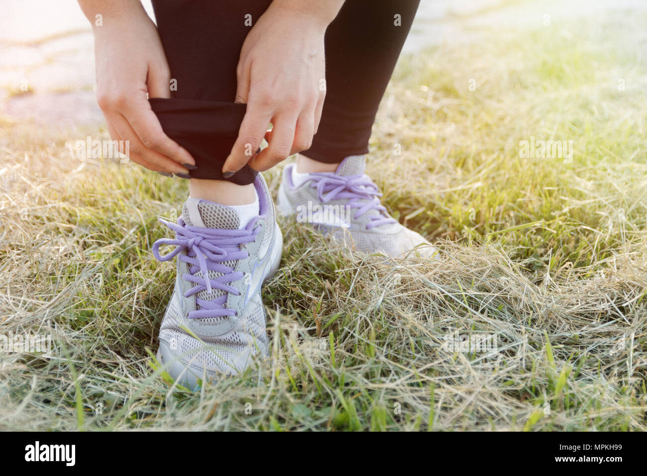 Deporte niña atándola de zapatos en la hierba Fotografía de stock - Alamy