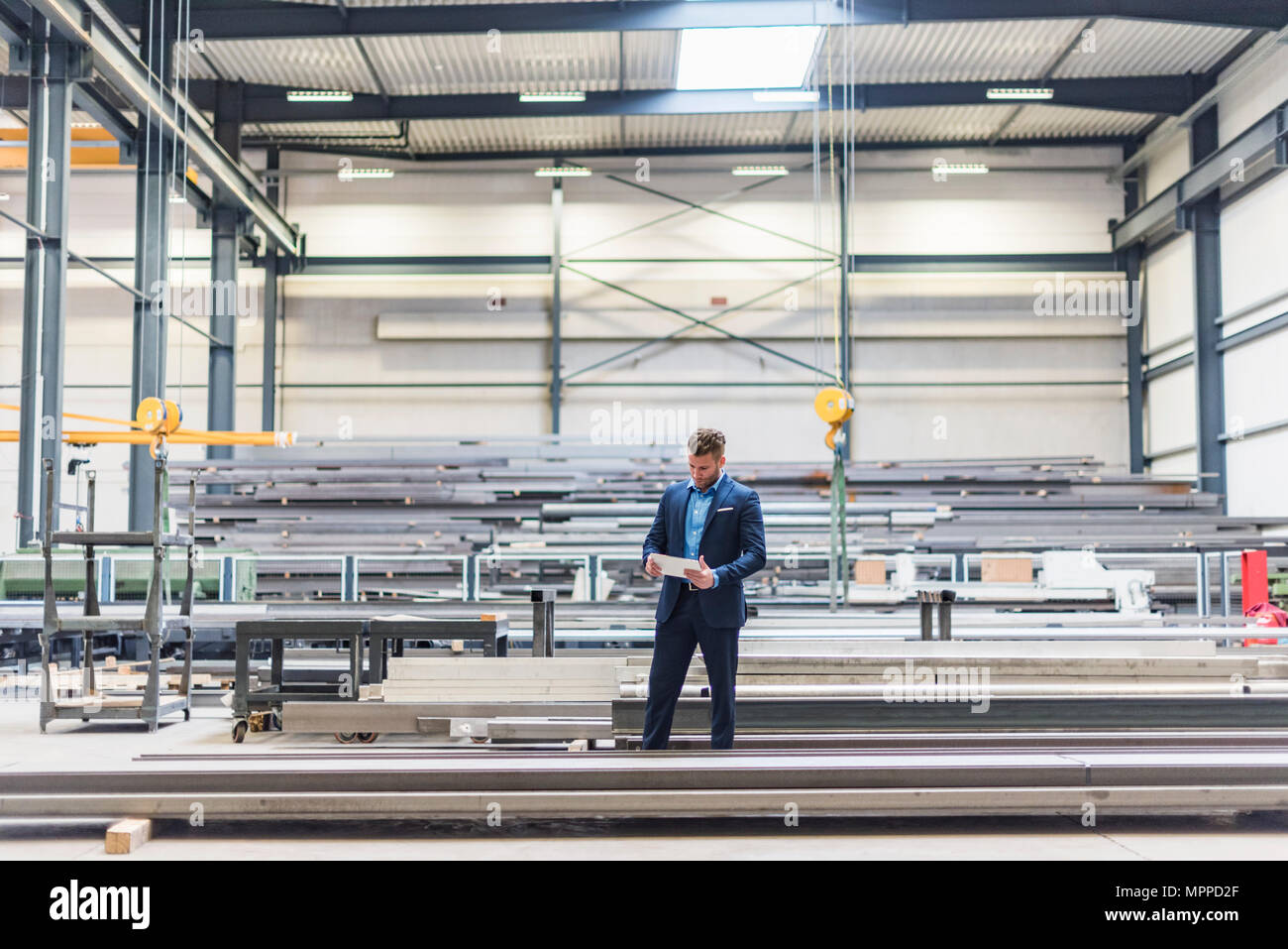 Empresario con tablet pararse en la planta de fabricación de fábrica Foto de stock