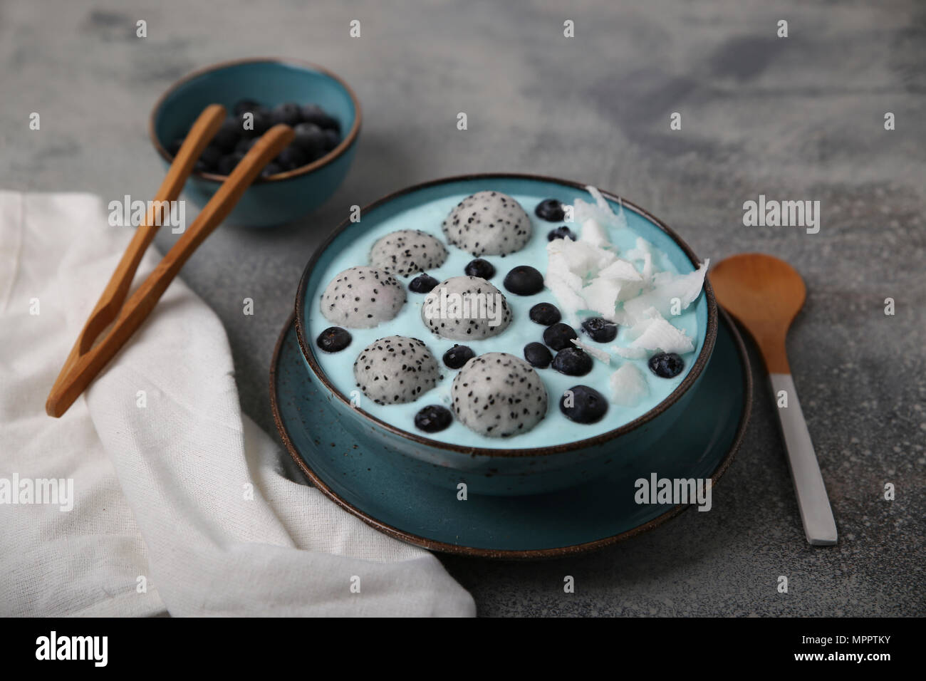 Smoothie azul recipiente con coco rallado, arándanos y fruta Dragon Balls Foto de stock