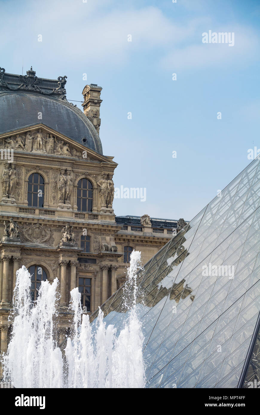 Una fuente con la vista de la pirámide y el Museo del Louvre Foto de stock
