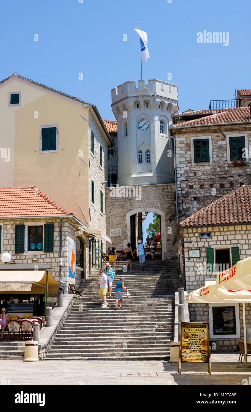Herceg Novi, Montenegro - Julio 8, 2015: Antigua puerta de la ciudad con el clocktower pequeña rodeada por casas antiguas Foto de stock