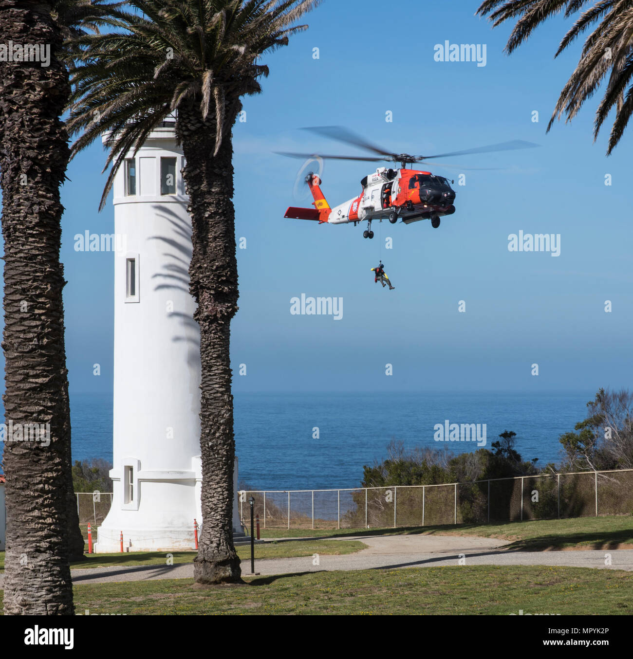 Una tripulación de Air Station San Diego es subirla un miembro hasta un guardacostas Jayhawk MH60 helicóptero de rescate durante el acantilado detrás del punto de capacitación Vicente Faro en Rancho Palos Verdes, California el 26 de abril de 2017. La formación contribuye consistentemente las tripulaciones estancia adepto de situaciones donde tendrán que realizar un acantilado de rescate. (Ee.Uu. Coast Guard foto por Suboficiales DaVonte 3ª clase' ósea) Foto de stock