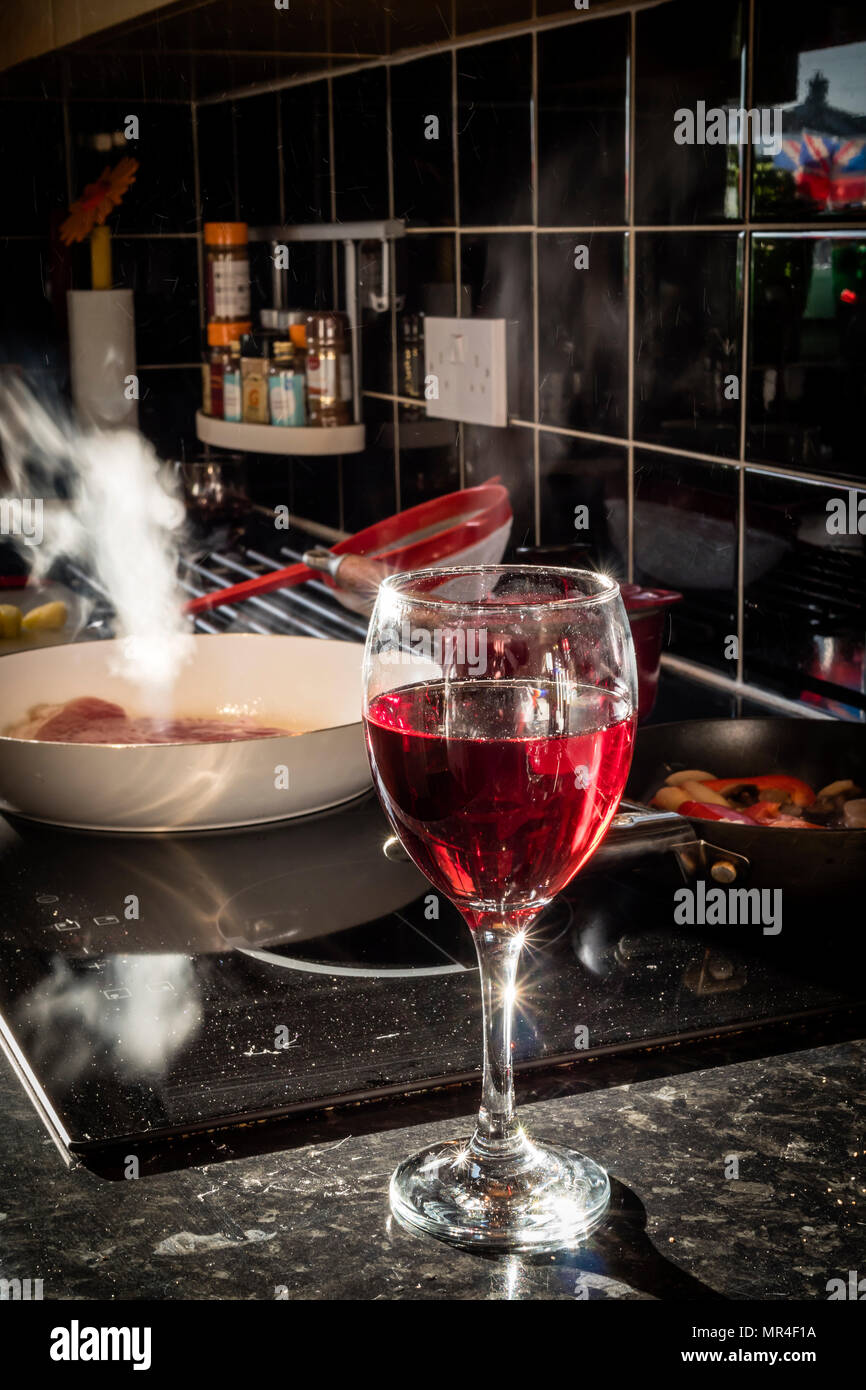 Home beber, cocinar y beber una copa de vino Foto de stock