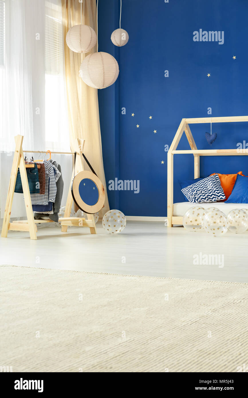 Habitación infantil de estilo creativo con perchero de madera y ropa de  cama Fotografía de stock - Alamy