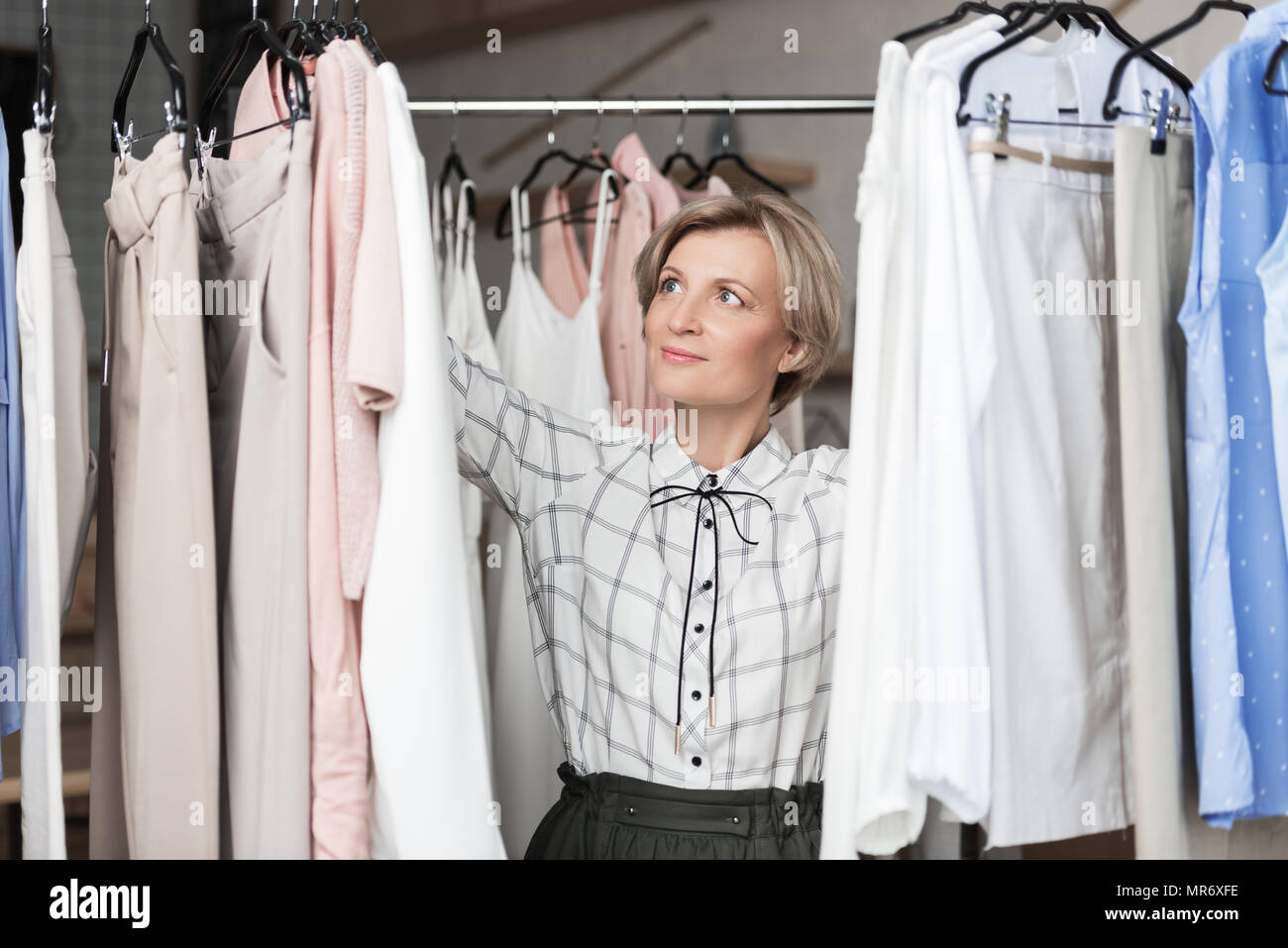 Mujer elegir blusas de filas en los puntos de venta Foto de stock