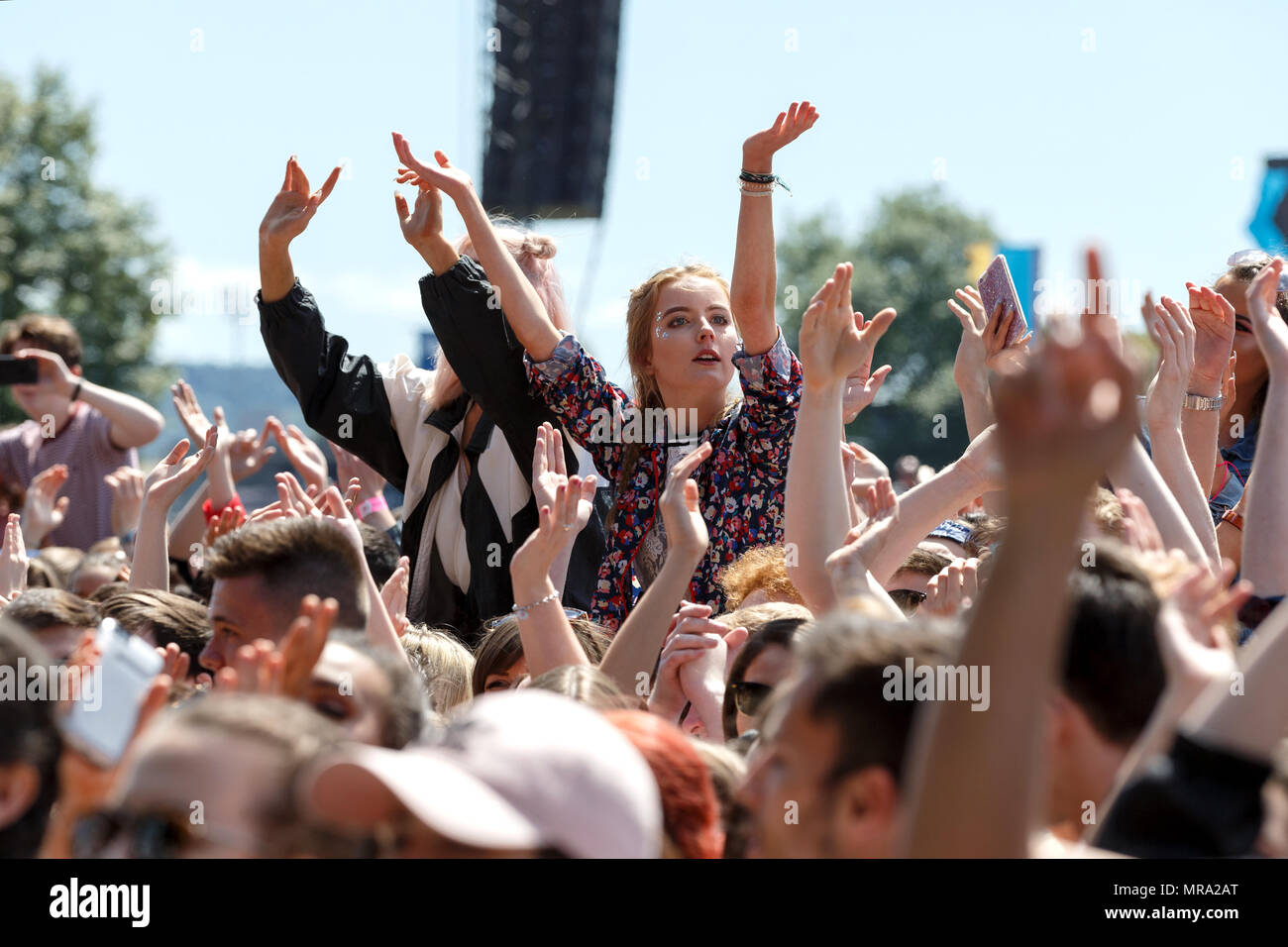 Una adolescente de pie en la muchedumbre en un festival de música. Foto de stock