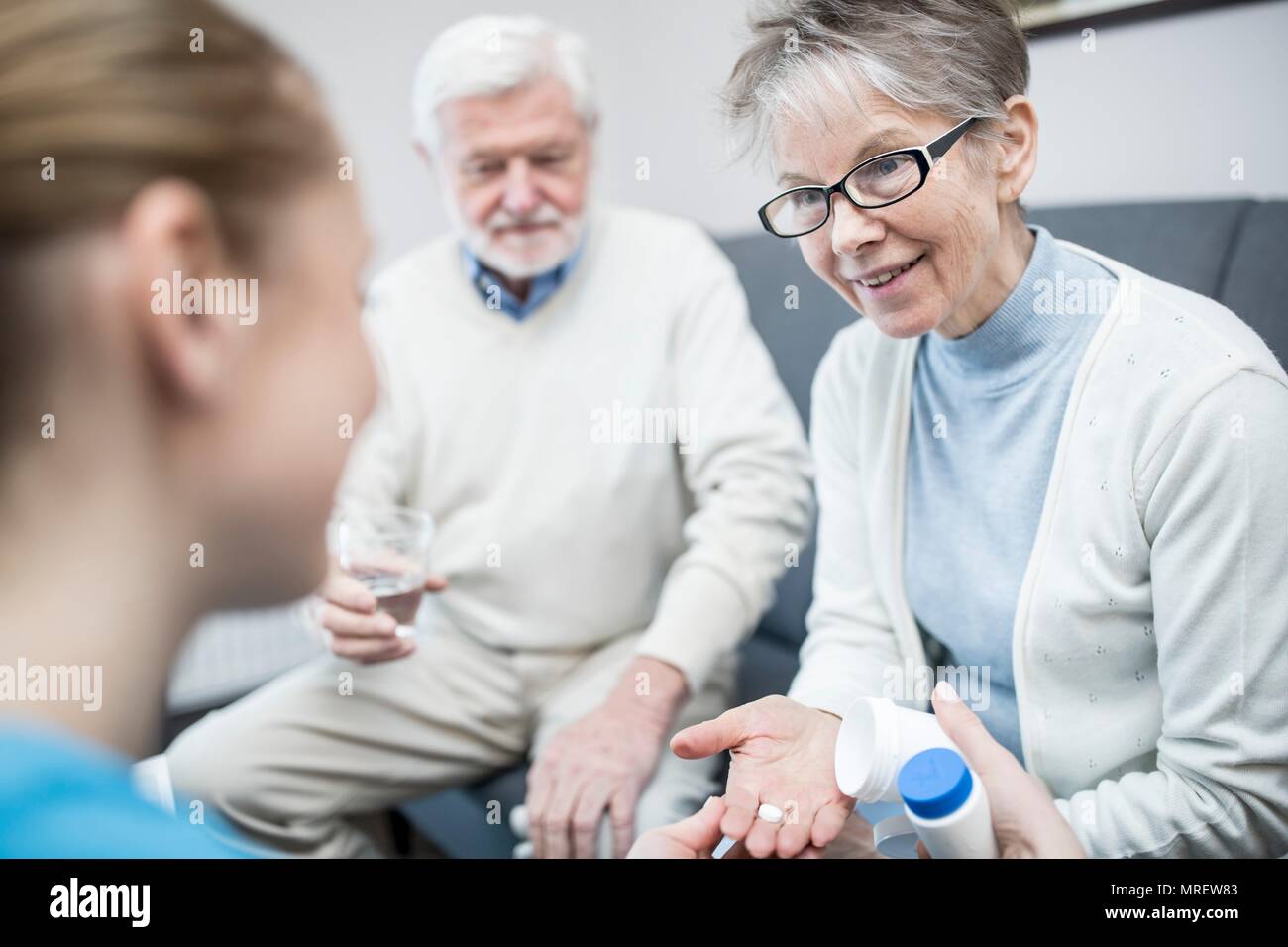 Mujer sosteniendo senior de medicamentos recetados en el cuidado en casa. Foto de stock