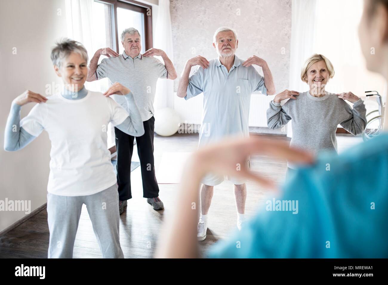Los adultos mayores hacer los ejercicios de clase. Foto de stock