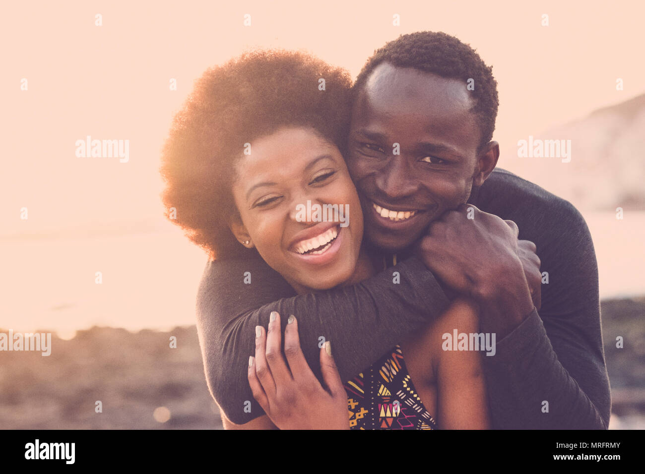 Hermosa raza negra modelo agradable par hombre y mujer joven abrazo y permanecer juntos con amor y amistad. outdoor pintoresco lugar cerca de la playa para Foto de stock