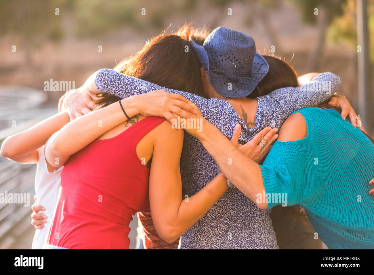 Union all acompañada como un trabajo de equipo y grupo de amigos mujeres 7 mujeres hermosas abrazo todos juntos bajo la luz del sol y al atardecer por la amistad y r Foto de stock