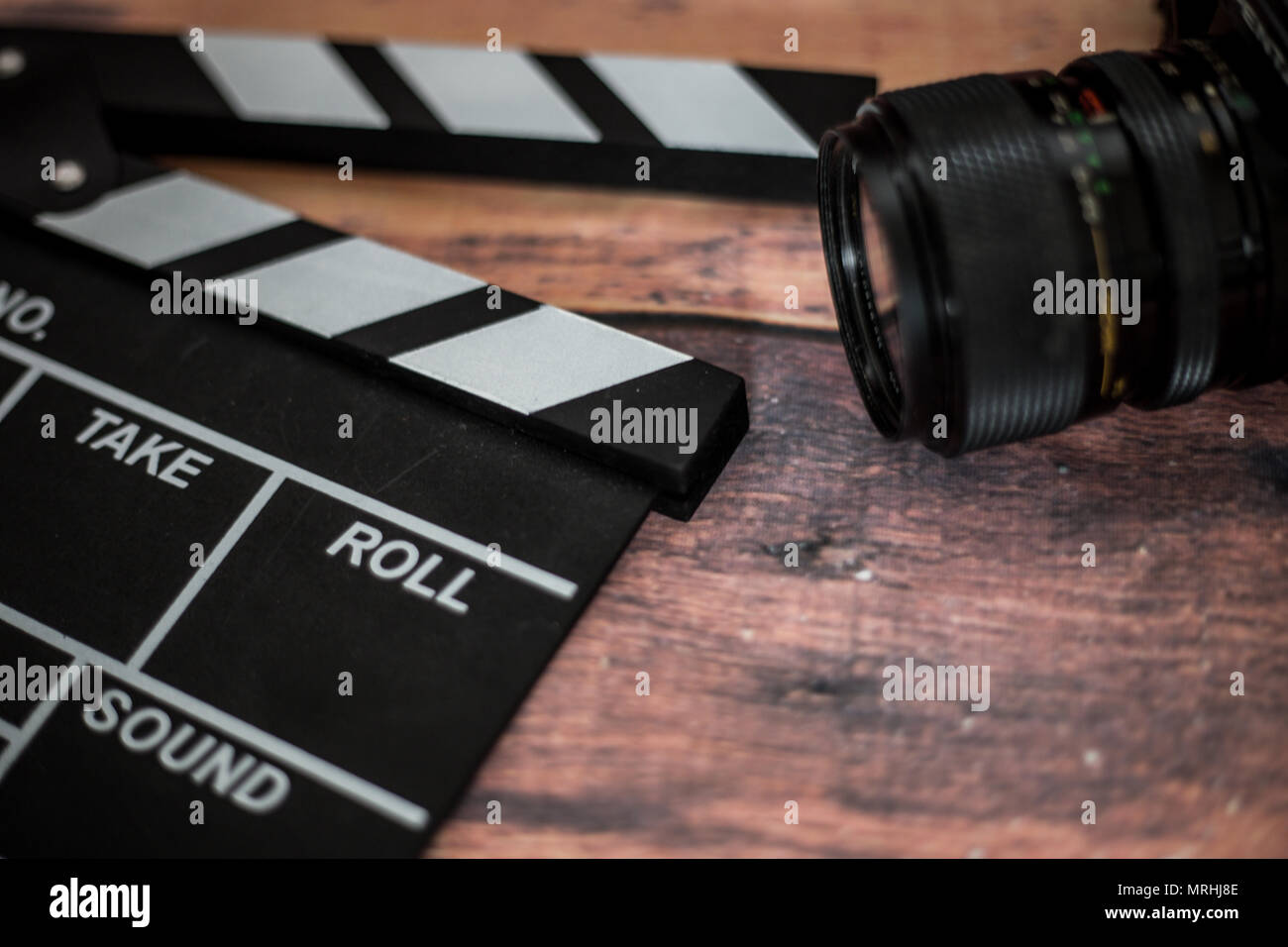 Clapeta de película y vieja cámara sobre un fondo de madera, grabación de vídeo, película, guión, director Foto de stock