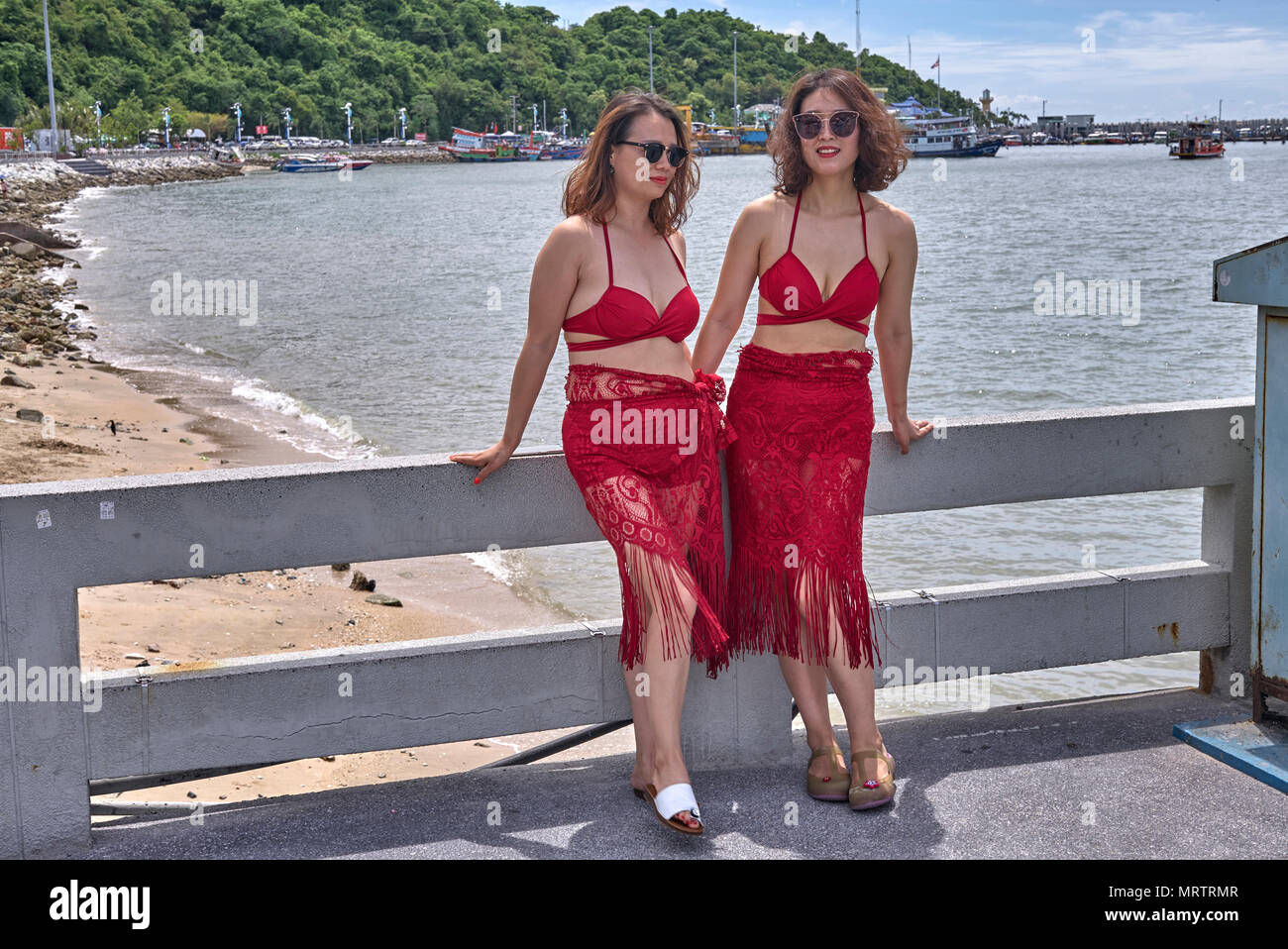 Dos mujeres vestidas igual en vestidos rojos. Tailandia Sudeste asiático Foto de stock