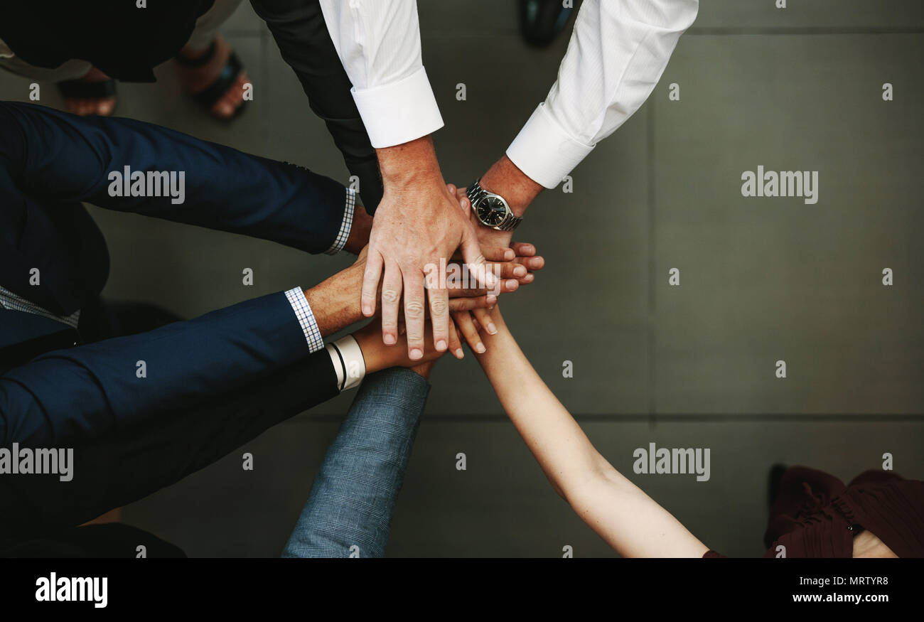 Concepto de la unidad y el trabajo en equipo. Vista superior de la gente de negocios poniendo su mano juntos. Foto de stock