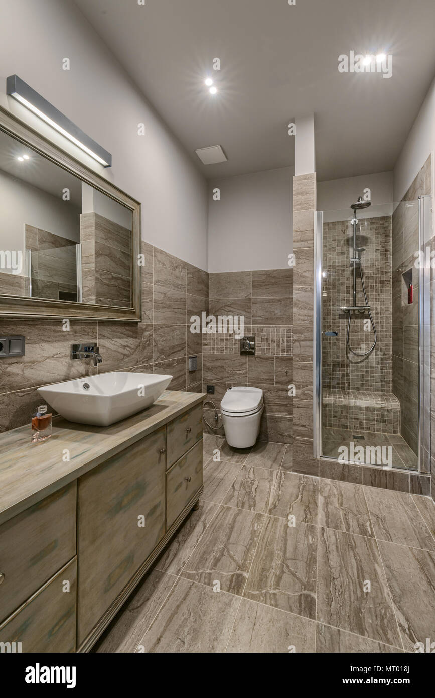 ven bañera Inodoro Baño interior con piso de baldosas y paredes de color marrón Fotografía de  stock - Alamy