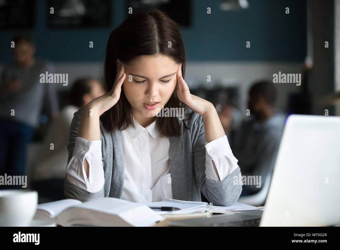 Destacado estudiante tenga dolor de cabeza preparando para el examen de prueba en cafe Foto de stock