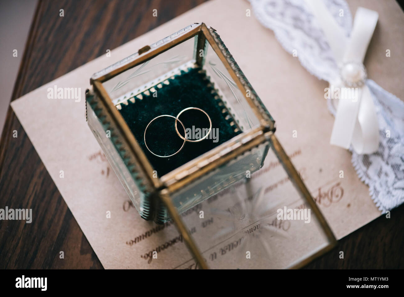 flotador Arriba Influyente Hermosos anillos de boda de oro dentro de una caja de cristal vintage,  sobre la invitación a la boda y de fondo de la tabla de madera Fotografía  de stock - Alamy