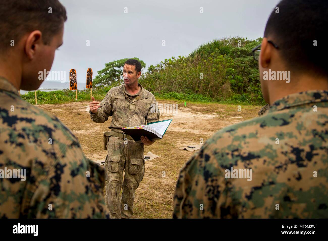 El Sargento del Ejército de Nueva Zelanda. Gral. Paul Buckley, sargento mayor de la compañía para la compañía Delta, explica a los Marines de Estados Unidos con el tercer batallón de Marines 4adjunta a la Task Force 17 Moana Koa, arma las reglas de seguridad antes de participar en un rango de fuego vivo durante el ejercicio TAFAKULA, en la isla de Tongatapu, Tonga, el 21 de julio de 2017. Ejercicio TAFAKULA está diseñado para fortalecer las militares, y las relaciones entre la comunidad de Tonga las Fuerzas Armadas de Su Majestad, el ejército francés de Nueva Caledonia, la Fuerza de Defensa de Nueva Zelandia, y las Fuerzas Armadas de los Estados Unidos. (Ee.Uu. Marine Corps photo by MCIPAC Combatir la cámara Lance Cpl. Foto de stock