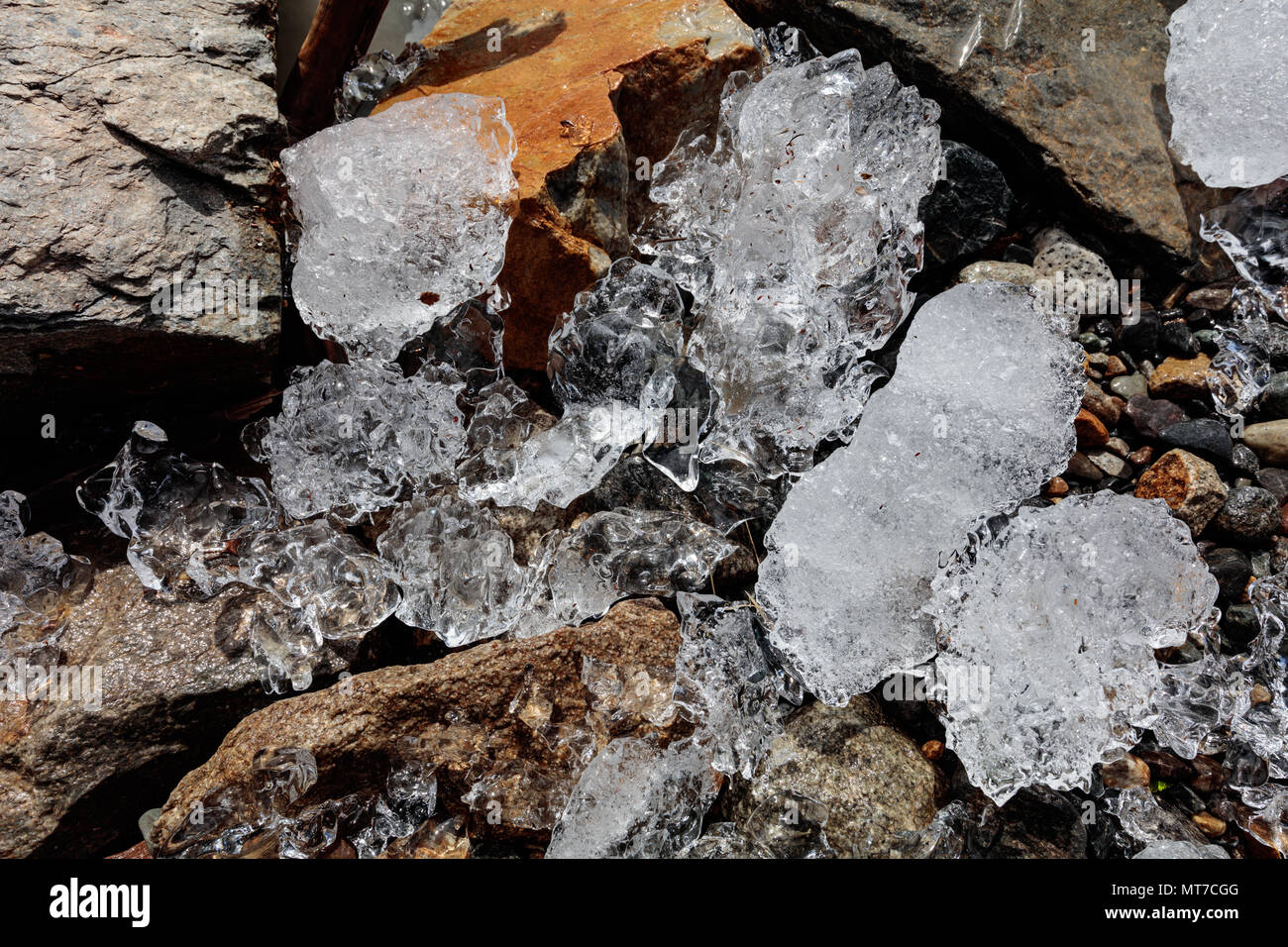 Pequeños bloques de hielo fresco mentira entre los fragmentos de roca en la orilla de un lago glacial en Fitzroy, Argentina Foto de stock