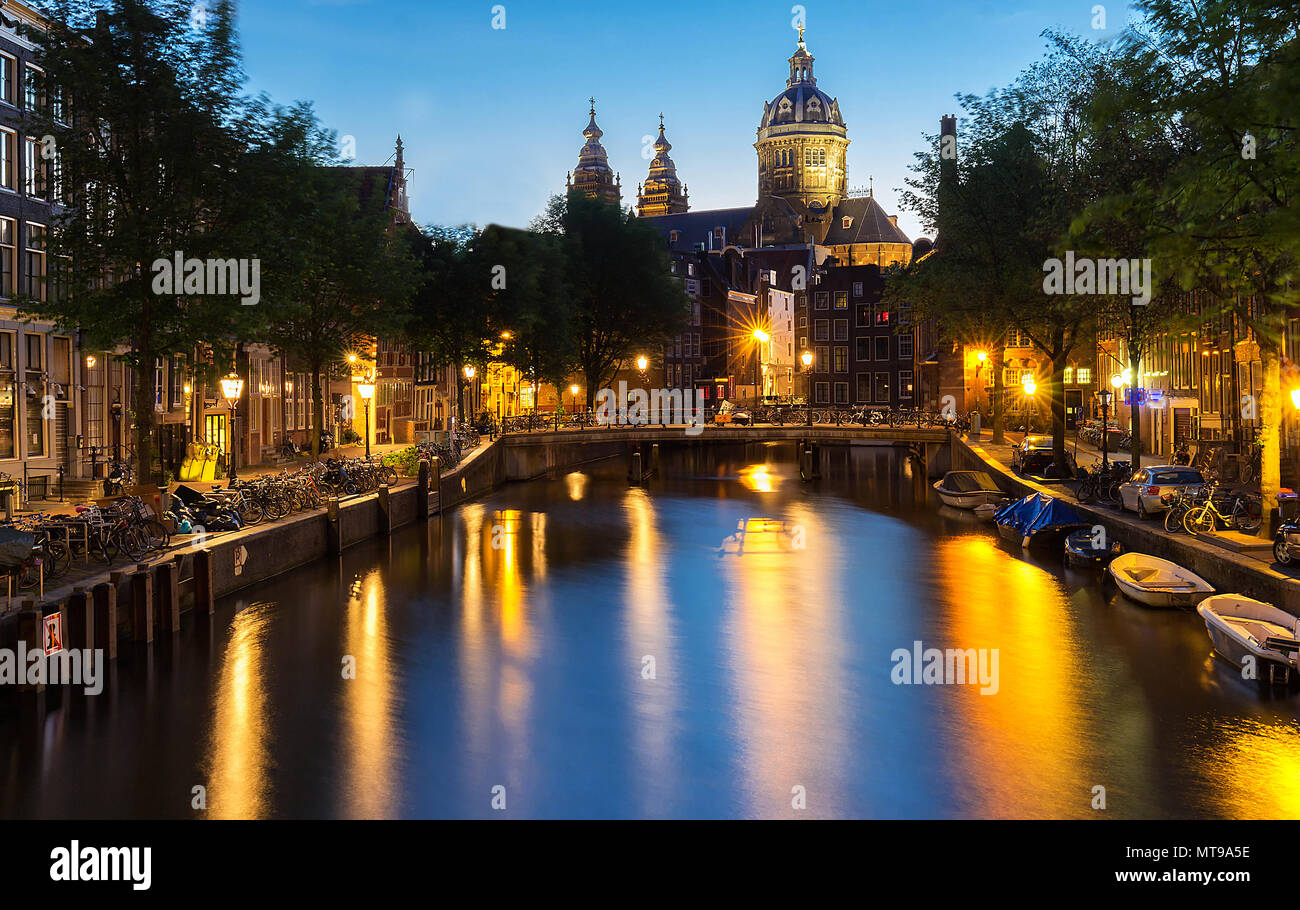 Noche distrito rojo De Wallen, canal, de la Basílica de San Nicolás y el puente, Amsterdam, Holanda. La larga exposición. Foto de stock