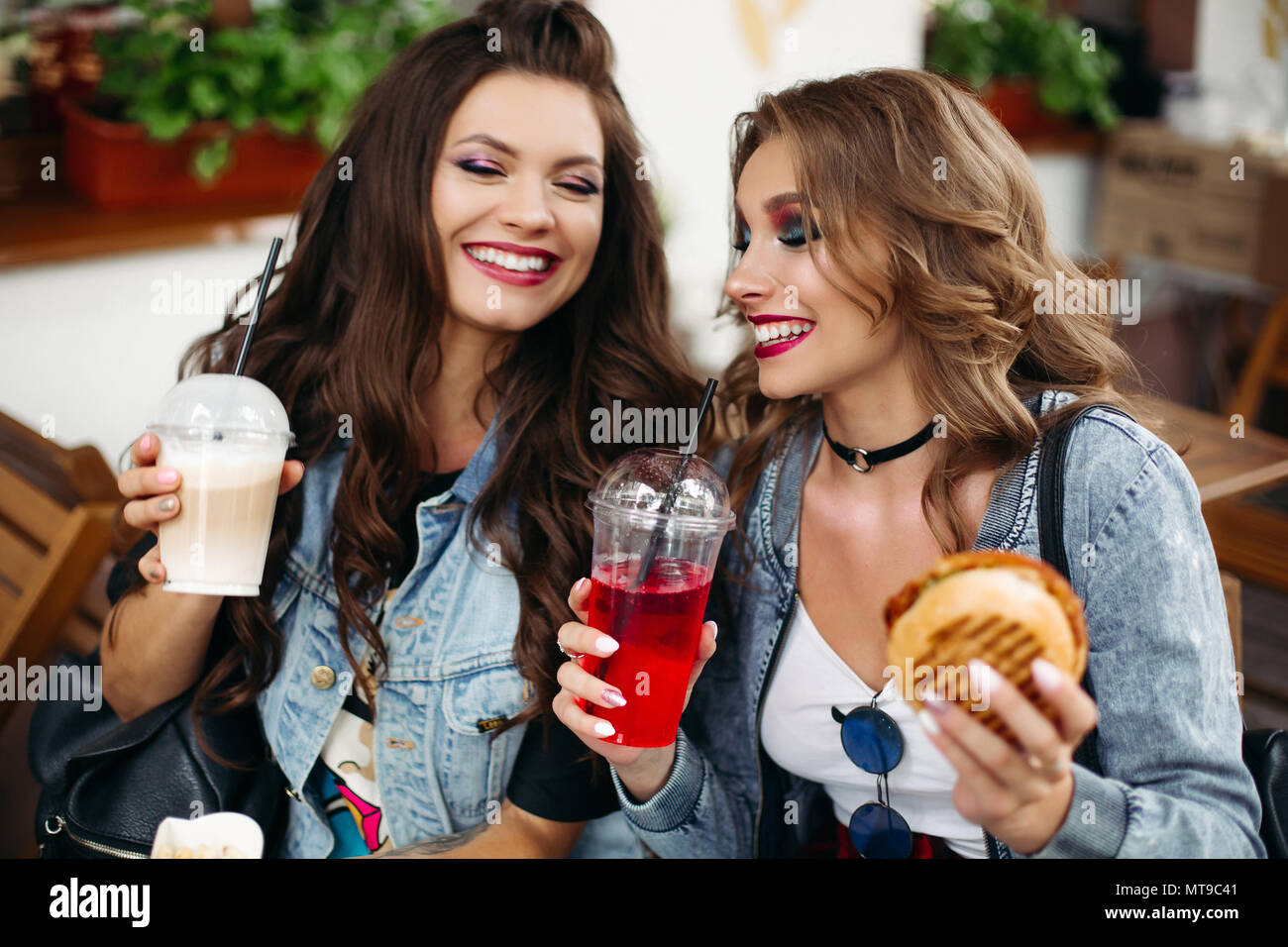 Novias felices disfrutando de las bebidas y la comida de la cafetería. Foto de stock