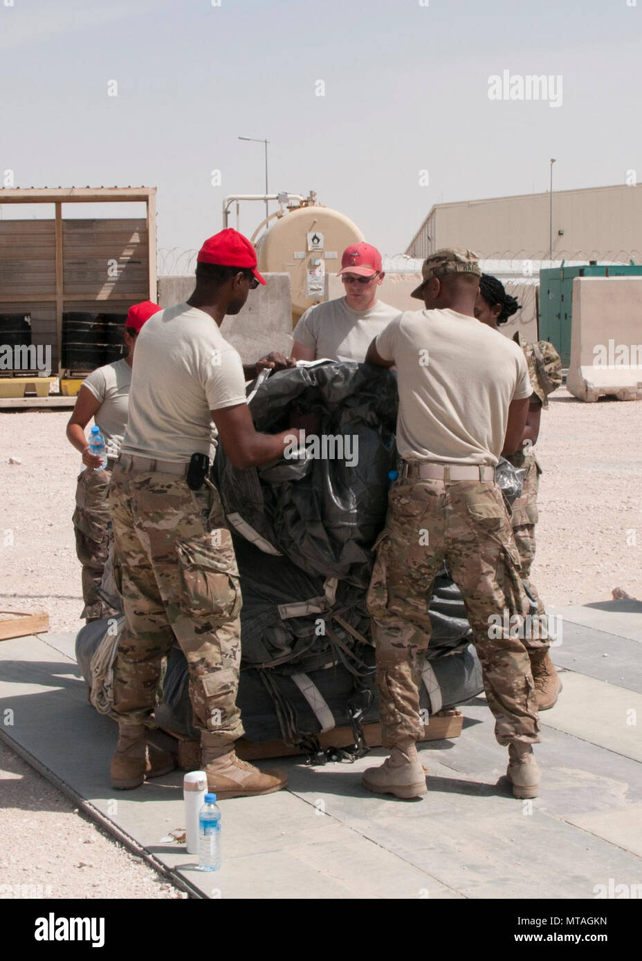 Los soldados de la 824ª Compañía de intendencia paracaídas pila utilizado para la entrega aérea en la base aérea de Al Udeid, Qatar, el 19 de abril de 2017. Operaciones de entrega aérea son esenciales para llevar suministros a las tropas en el Oriente Medio cuando los medios convencionales de transporte no son factibles. Foto de stock