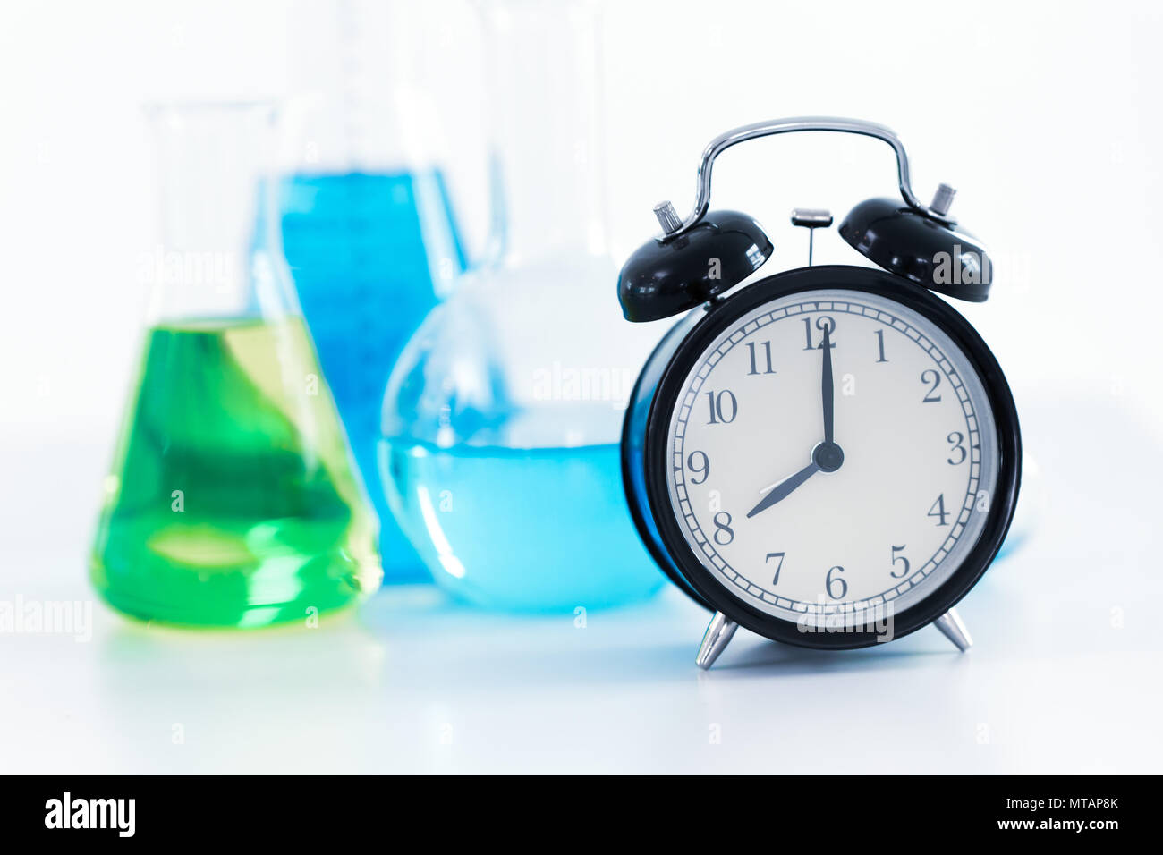 8 o'clock Reloj retro con la ciencia química laboratorio de investigación médica antecedentes Foto de stock