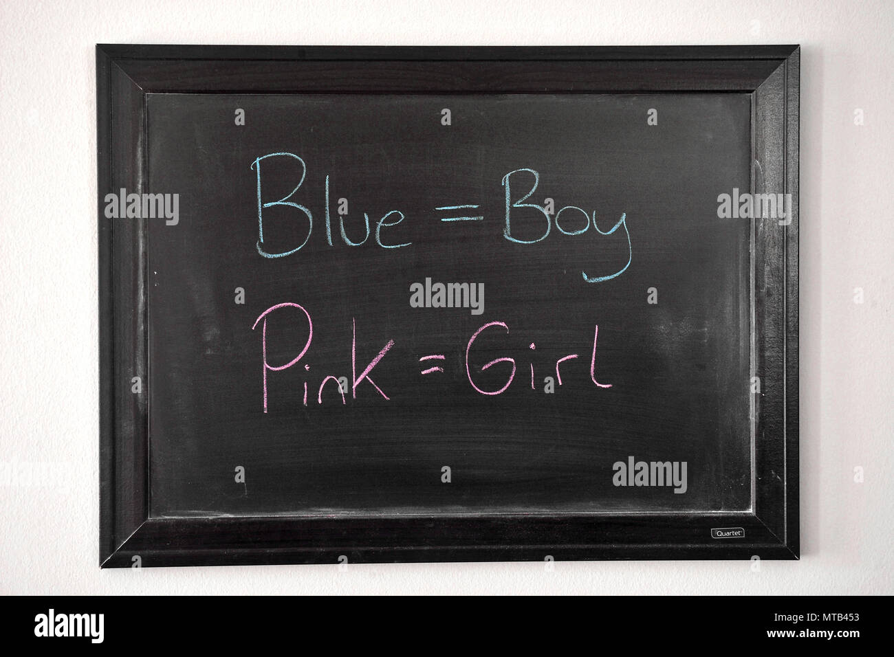 Blue Boy niña Rosa escrito en azul y rosa tiza en una pizarra en la pared Foto de stock