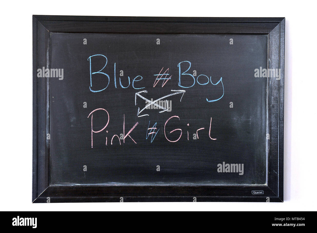 Blue Boy niña Rosa escrito en azul y rosa tiza en una pizarra en la pared Foto de stock